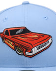 front closeup view of sky blue Fresno Grizzlies Lowriders fitted hat showing the red lowrider classic car logo